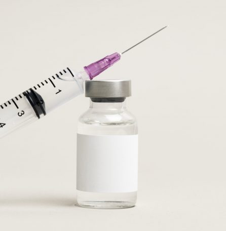 Blank white label on injection bottle glass vial with syringe